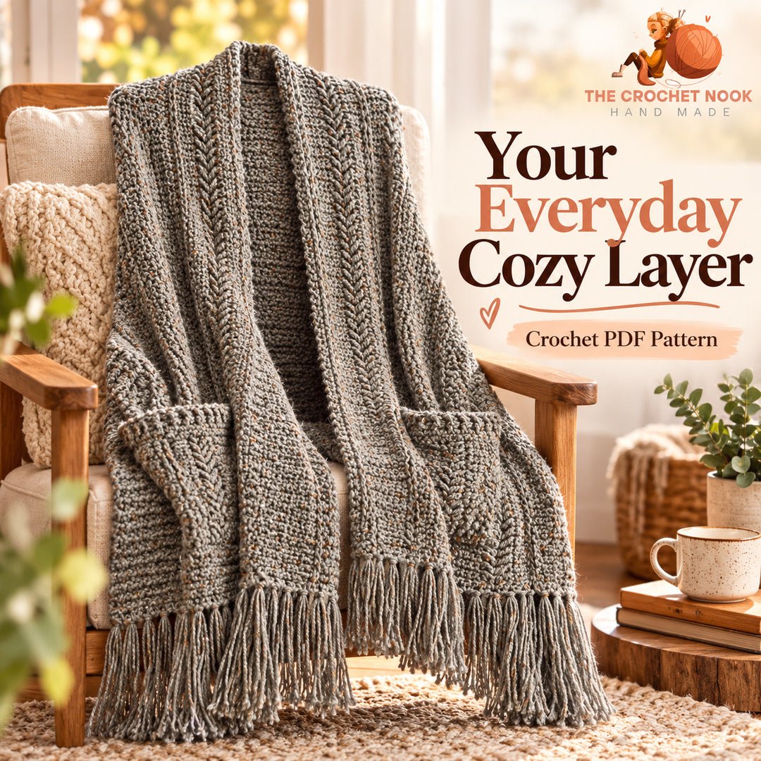 Heather Trails Textured Pocket Shawl Crochet Pattern — gray tweed pocket shawl with two pockets and fringe draped on an armchair. Digital pattern.